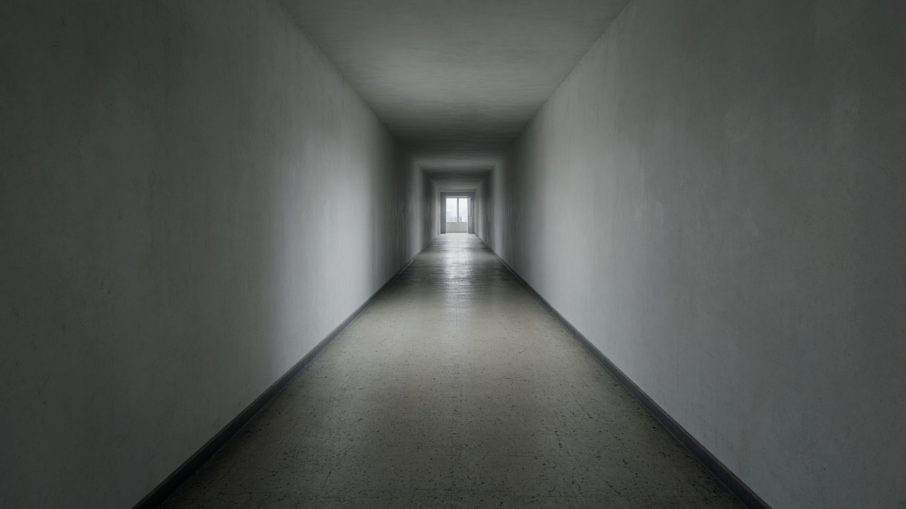 A long empty corridor ending in a small square of daylight