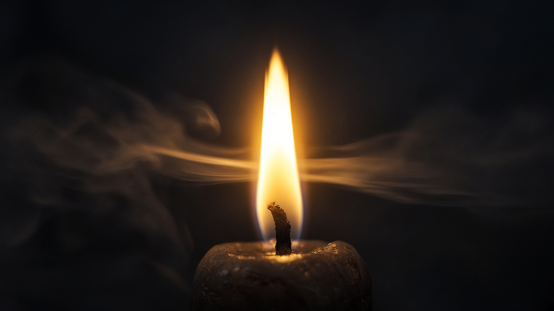A candle flame and a ribbon of breath in cold dark